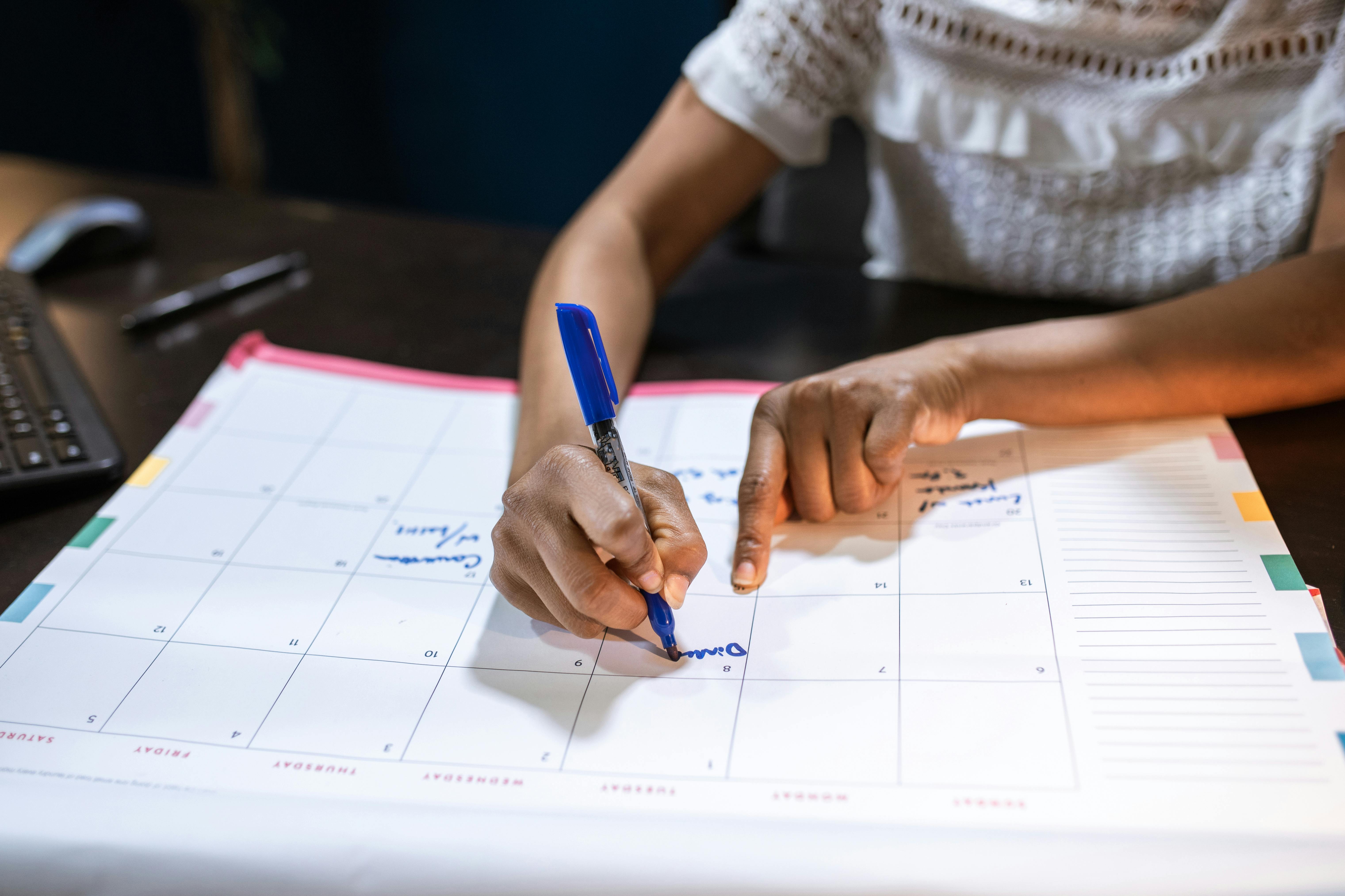 Practitioner planning a new social value measurement cycle at the start of the financial year, writing outcomes and milestones into a calendar alongside a laptop